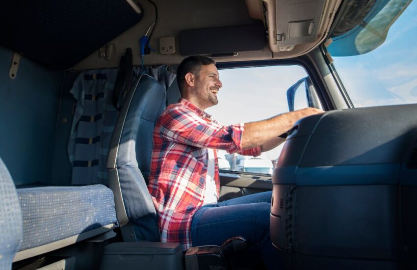 imagem representando aposentadoria do caminhoneiro com homem sorrindo dentro do caminhão